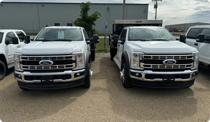 Two ford trucks in parking lot in a sunny day